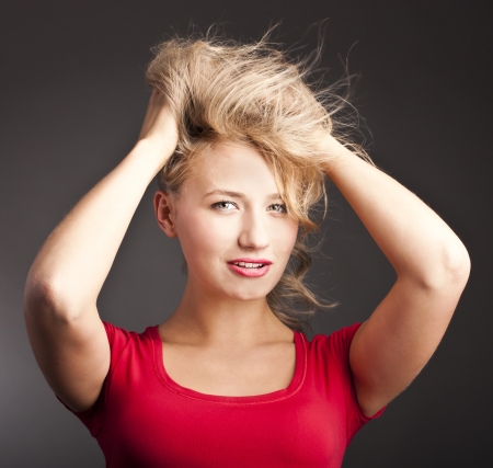Blonde laughs in studio. Wonderful smile, red lipstick. Portrait of a black backgroundの写真素材