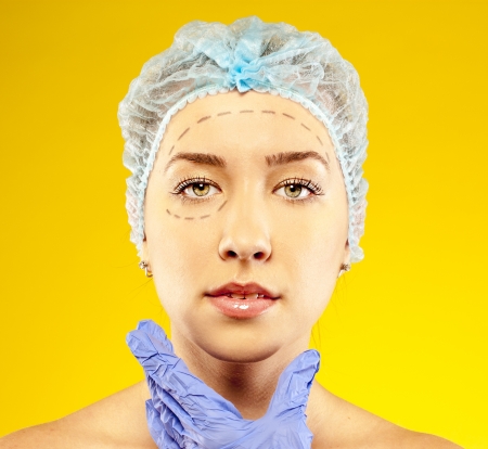 woman on the examination, the doctor  before plastic surgery  yellow backgroundの写真素材
