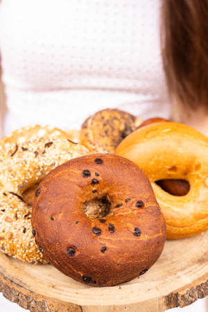different types of bagels on a wooden tray