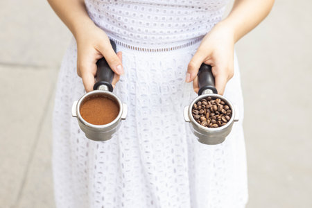 Woman holds ground coffee and grains in her handsの写真素材