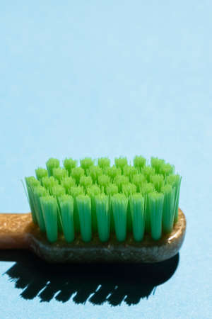 Close up of plastic green toothbrush on blue . Free copy space.の写真素材