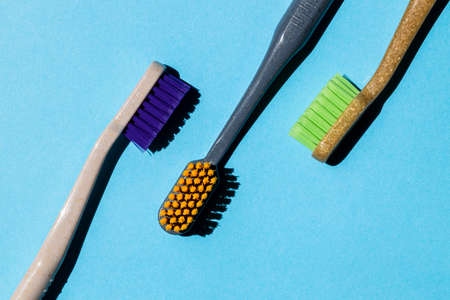 three different toothbrushes on a blue backgroundの写真素材