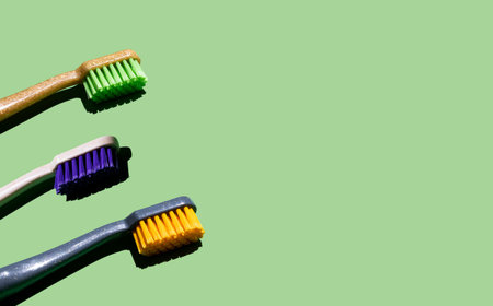 different toothbrushes on a light green background. Place for your textの写真素材