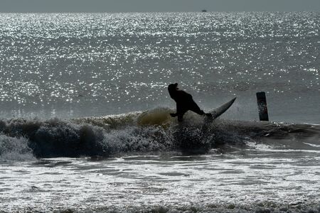 Silhouette of a surfer riding the waves at dusk in Florida