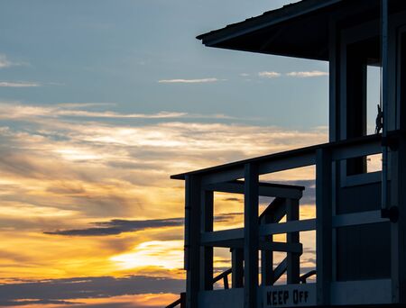 Life guard tower at the beach as the sun sets in the distanceの写真素材