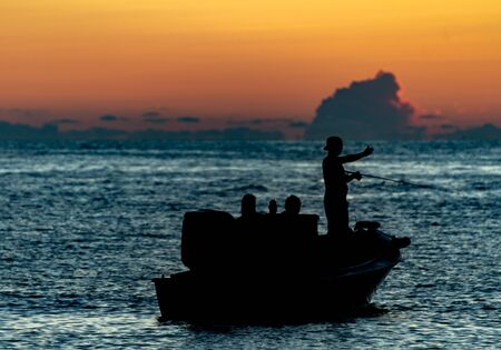 Silhouette of fishermen on the Gulf of Mexico at sunsetの写真素材