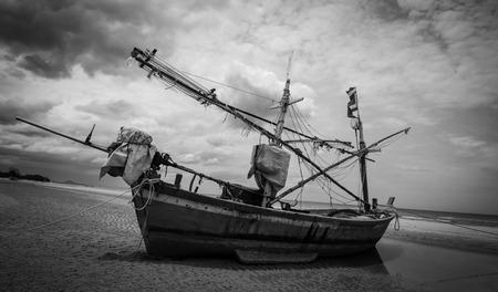 Thai fishing boat on the beach used as a vehicle for finding fish in the sea with sky. Black and white styleの写真素材