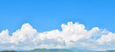 Panorama of blank blue sky and clouds with green mountainの写真素材