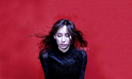 Dark girl doing meditation on red backgroundの写真素材