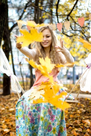 Happy girl throws colorful autumn leavesの写真素材