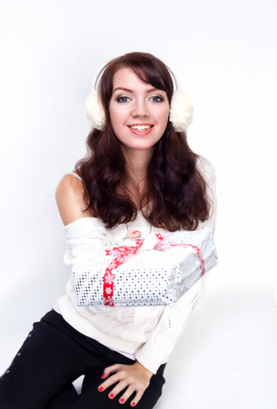 Smiling girl giving you a present on white backgroundの写真素材