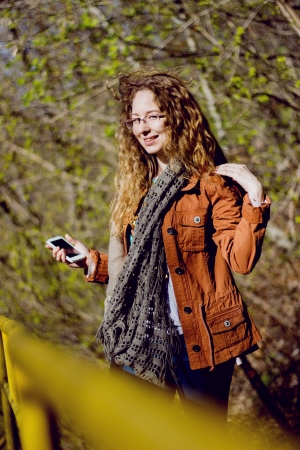 Happy woman with glasses and curly hair on sunny forest backgroundの写真素材
