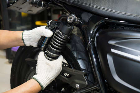 motorcycle mechanic check and Change rear Shock Absorbers motorcycle scooter at garage,motorcycle repair, maintenance and service conceptの写真素材