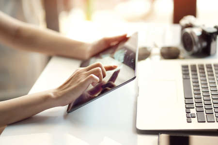 Young women holding and using the digital tablet on the internet ,touch on screen pad and connecting to wireless wifi at home office , selective focusの写真素材