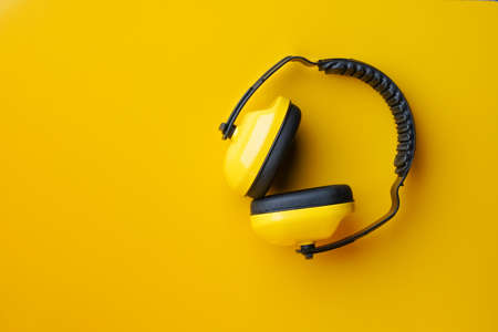Protective ear muffs on yellow background .safety first conceptsの写真素材