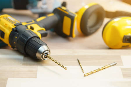 Dill bit. Power drill or Cordless screwdriver on Walnut Plywood in workshop, woodworking Handicraft...