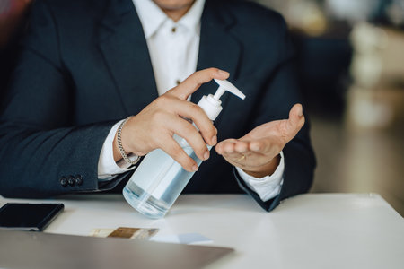 man washing hands with alcohol gel or antibacterial soap sanitise after using a public restroom.の写真素材