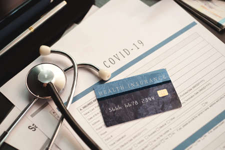 Coronavirus or COVID19  insurance policy document on desk, Health Care Insurance Plan concept.の写真素材
