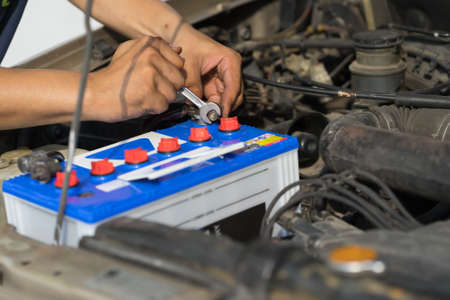 Male mechanic changing car batteryの写真素材