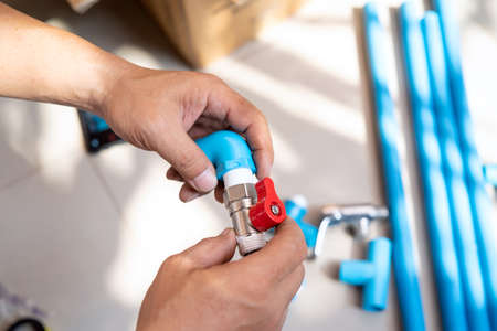 plumber putting thread tape on the thread , Preparing to connect to PVC Pipe at homeの写真素材