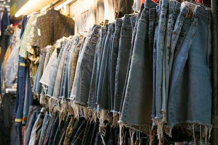 Used Clothing hanging in second hand store at Chatuchak weekend market Bangkok  ,selective focus