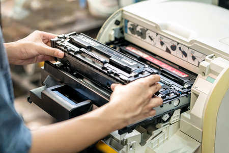 Women holding Laser toner cartridge ,replacing toner in laser printer at office. Repairs and Maintenance Laser printers conceptの写真素材