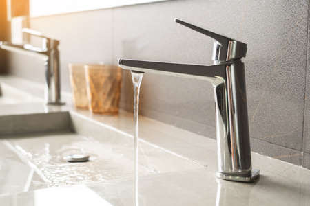 Basin faucet and Water running from a Stainless steel water tap in bathroom,save energy conceptの写真素材