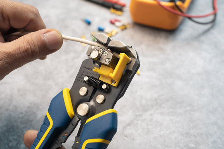 Wire strippers or cable strippers tool . Electrician holding cable strippers tool  to remove...