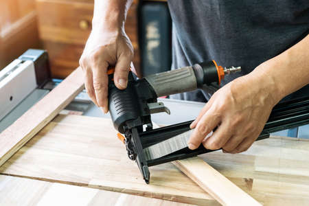 carpenter load nails into a nail gun ,furniture restoration woodworking concept. selective focusの写真素材