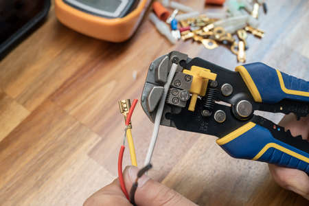 Wire strippers or cable strippers tool . Electrician holding cable strippers tool to remove insulation from electrical wires.Work Safely and Tools conceptの写真素材
