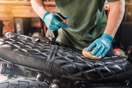 Man spraying to cleaning and protect leather motorcycle seat, maintenance motorcycle concept .selective focus on seat ,の写真素材