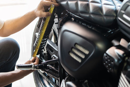 mechanic using tape measure set up suspension sag Compression and Rebound on motorcycle at garage,  repair and maintenance motorcycle concept .selective focusの写真素材