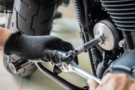 mechanic use oil filter wrench removal tool on motorcycle at garage ,concept of motorcycle maintenance and repair. selective focusの写真素材