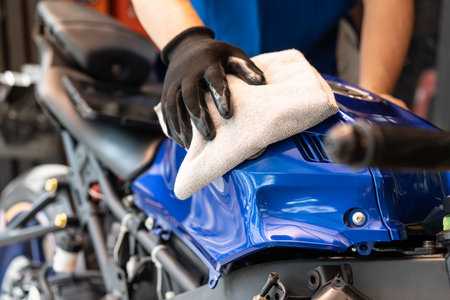 Biker man cleaning motorcycle , Polished and coating wax on fuel tank at garage. motorcycle maintenance and repair concept.の写真素材