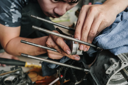 Mechanic is installing a motorcycle piston in garage.Disassembly and maintenance of motorcycle...