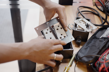 Man Install an Electrical Outlet Receptacle in to rubber box , Attach the Receptacle to the Box