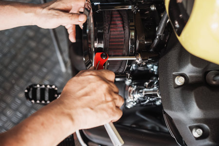 Motorcycle mechanic using Hex key wrench working on motorcycle at motorbike garage , maintenance and repair concept .の写真素材