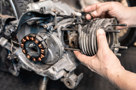 Motorcycle mechanic repairing motorcycle, overhaul and removing cylinder block in repair shop, maintenance and repair motorcycle conceptの写真素材
