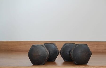 Old iron dumbbells or exercise weights outdoor on a wooden floorの写真素材