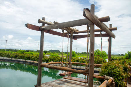 Green water views, beautiful flowers surrounded, and blur wooden swings, perfect for relaxing during holidays.の写真素材