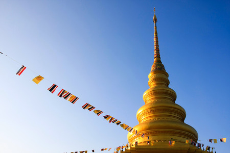 Golder pagoda tying up by Thailand flag with sky backgroundの写真素材