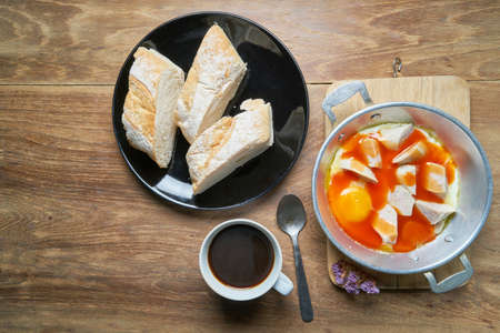 A cup of coffee with fresh sliced Italian bread and panned egg and sausageの写真素材