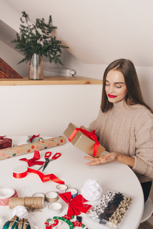 Beautiful girl packing Christmas or new year gifts. Happy Christmas concept, handmade, family celebratingの写真素材