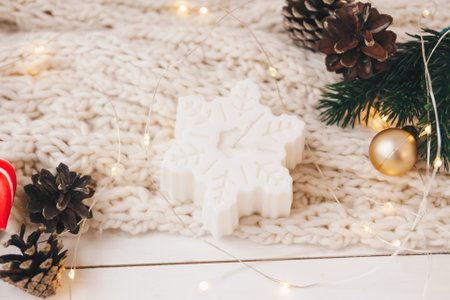 Cozy candle as snowflake with Christmas decoration on the white and knitted background. New year or Christmas holiday concept, holidays cardの写真素材