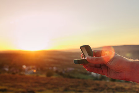 Man holding a box with diamond engagement in front of mountains and beautiful sunset. Proposal of marriage to a woman or a man in a beautiful place. Copy space for your or advertisementの写真素材