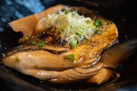 Salmon kabutoni, Salmon head in soya sauce with sliced â€‹â€‹spring onion on top served in...