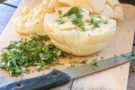 Coriander and garlic sliced on wooden plate with a knife and bunの写真素材