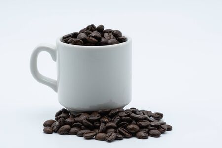 Coffee seed in a white ceramic cup on a white backgroundの写真素材