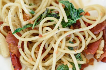 Spaghetti carbonara with crispy bacon on a white plateの写真素材