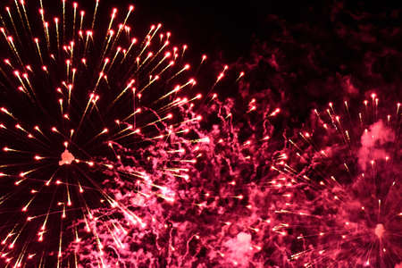 Close-up fireworks explode in the sky with motion blur on a black background.の写真素材